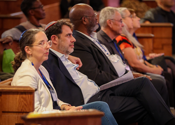 Some of the EMI partners sitting in the pews, listening at an event.